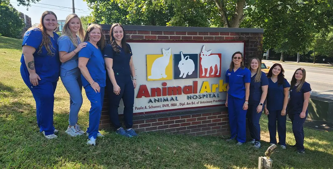 Team Standing By Outside Sign